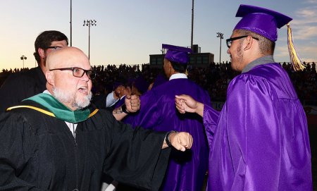 Perfect evening for 'Pomp and Circumstance' at Lemoore High School Graduation Teacher Howard Clarke fist bumps a student at graduation.